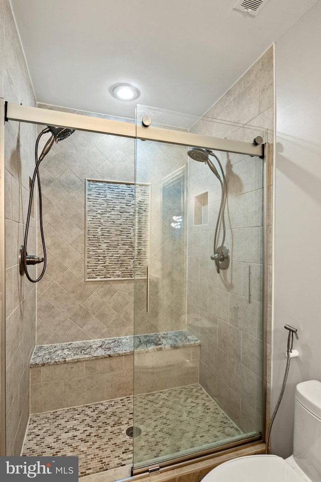 bathroom with an enclosed shower and toilet