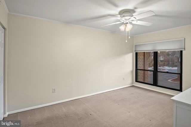 carpeted spare room with ornamental molding and ceiling fan