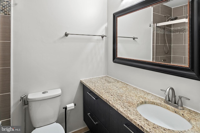 bathroom featuring vanity, toilet, and walk in shower