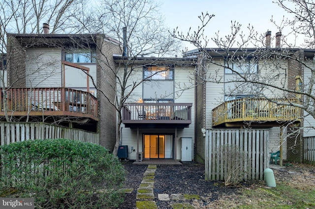 back of house with a deck and central air condition unit