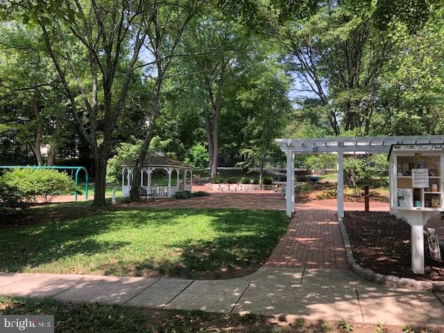 surrounding community with a gazebo, a pergola, and a lawn