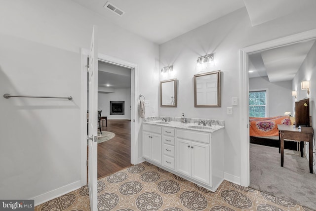 bathroom with tile patterned floors, a fireplace, and vanity