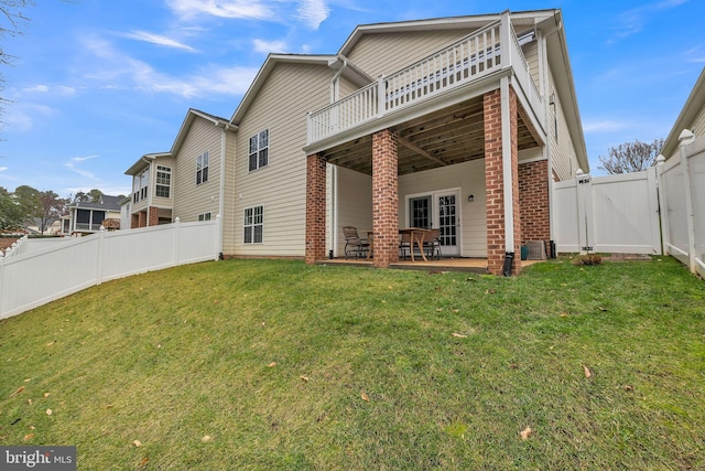 rear view of property with a patio and a yard