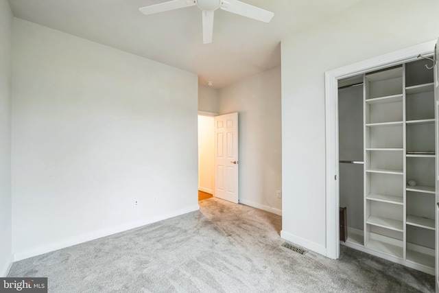 unfurnished bedroom with light colored carpet, a closet, and ceiling fan