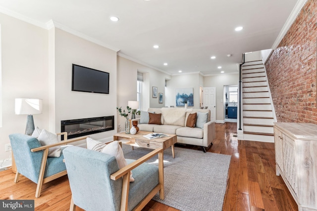 living room featuring ornamental molding, brick wall, and hardwood / wood-style floors