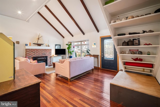 living room featuring beam ceiling, a brick fireplace, hardwood / wood-style flooring, and high vaulted ceiling