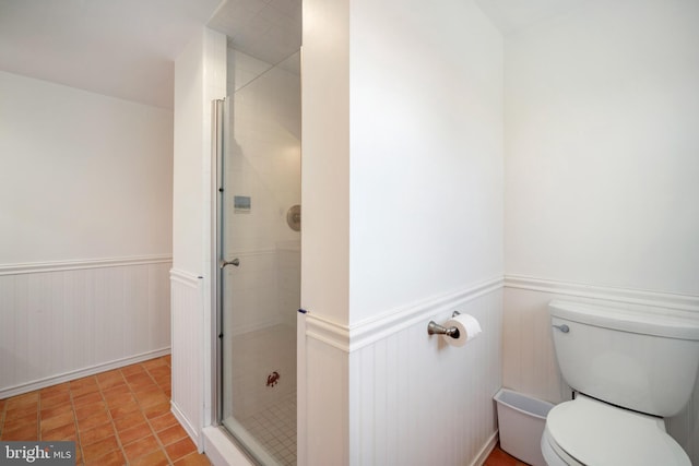 bathroom with tile patterned flooring, a shower with door, and toilet