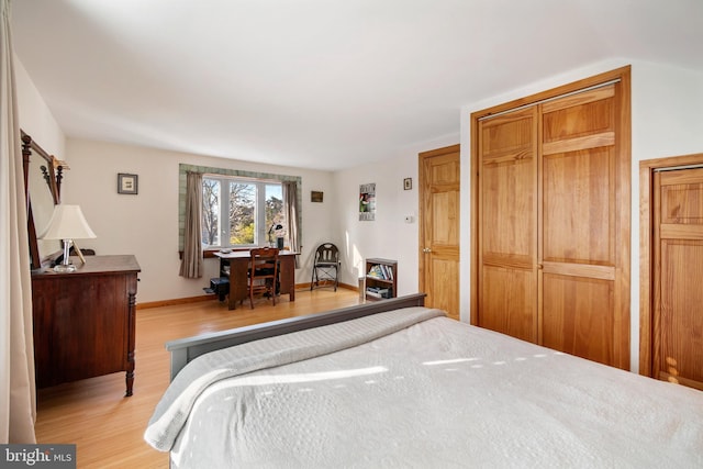 bedroom with light hardwood / wood-style floors and a closet