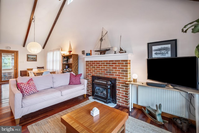 living room featuring dark hardwood / wood-style flooring, a wood stove, and vaulted ceiling with beams