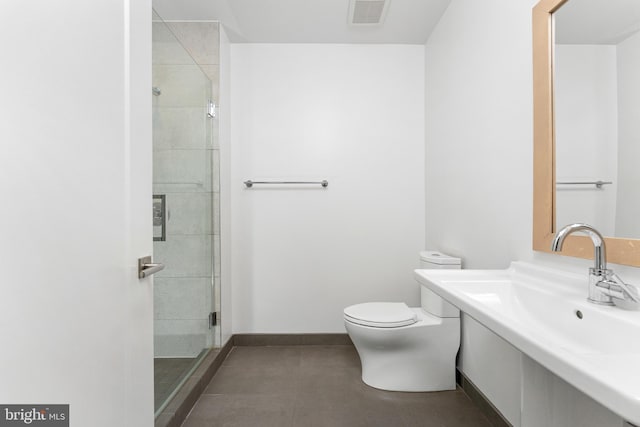 bathroom with a shower with door, sink, tile patterned floors, and toilet