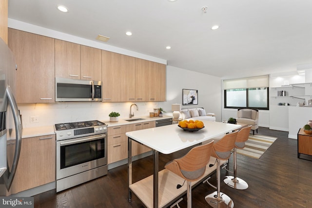 kitchen featuring light brown cabinetry, sink, dark hardwood / wood-style flooring, decorative backsplash, and stainless steel appliances