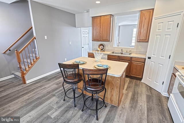 kitchen featuring sink, a center island, dark hardwood / wood-style floors, white range with electric stovetop, and a kitchen bar