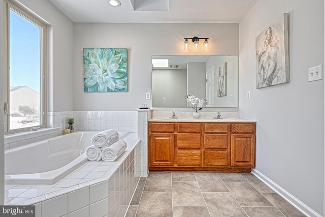 bathroom featuring vanity and tiled bath