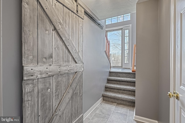 staircase with tile patterned flooring and a textured ceiling