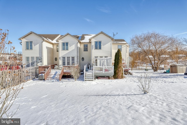 snow covered house featuring a deck