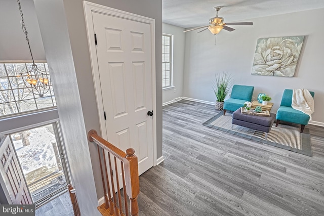 sitting room featuring hardwood / wood-style floors and ceiling fan with notable chandelier