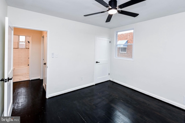 spare room featuring ceiling fan, dark hardwood / wood-style floors, and a healthy amount of sunlight