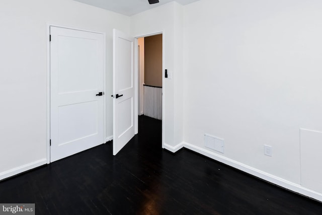 unfurnished bedroom with dark wood-type flooring