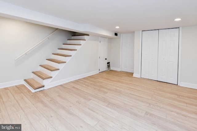 basement with light hardwood / wood-style flooring