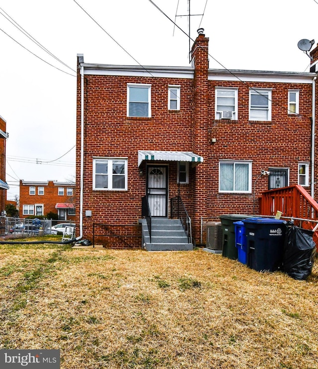 back of property with a yard and central air condition unit