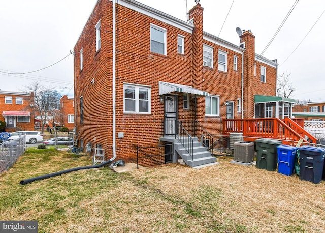 back of property featuring cooling unit and a lawn