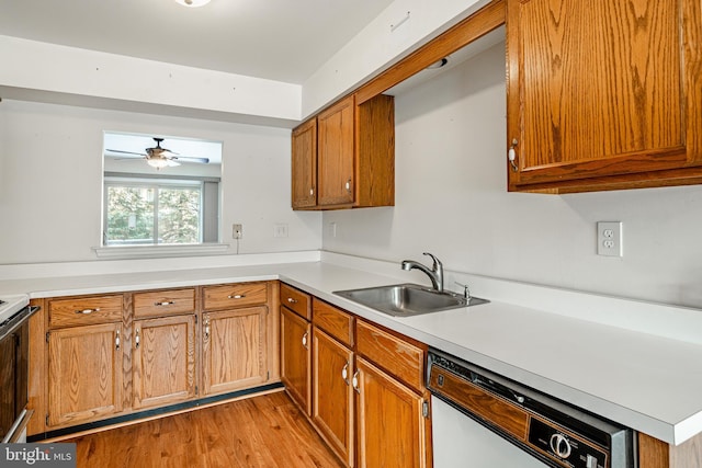 kitchen featuring ceiling fan, dishwasher, sink, and light wood-type flooring