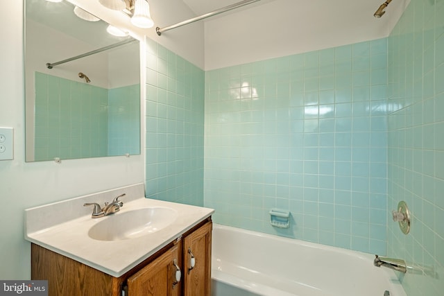 bathroom featuring tiled shower / bath combo and vanity