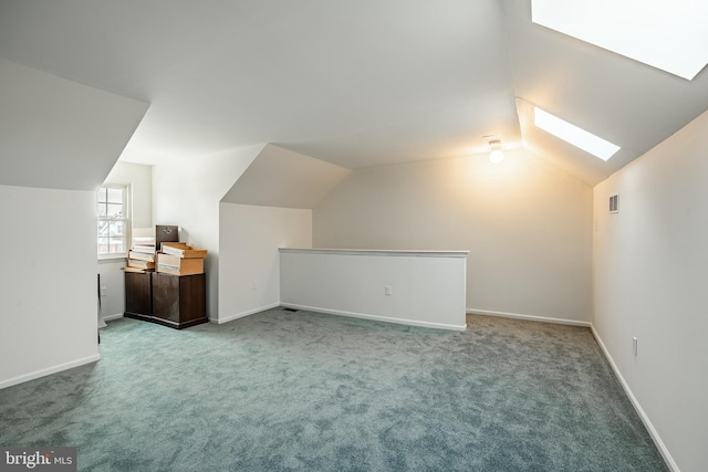 additional living space featuring carpet flooring and vaulted ceiling with skylight