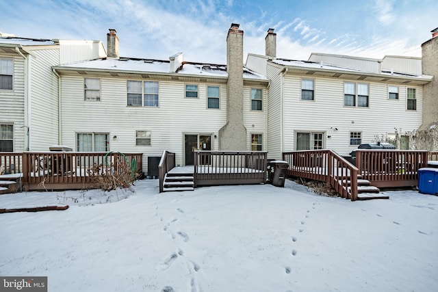 snow covered rear of property featuring a wooden deck