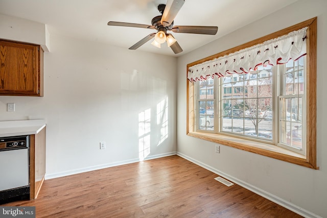 unfurnished dining area with ceiling fan and light wood-type flooring