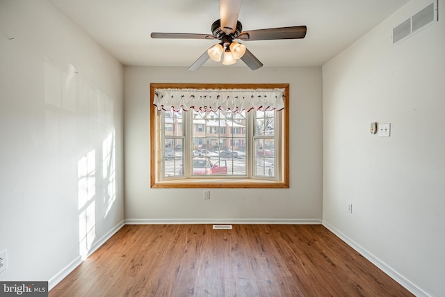 empty room with hardwood / wood-style flooring and ceiling fan