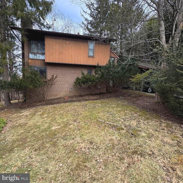 view of side of home with a yard