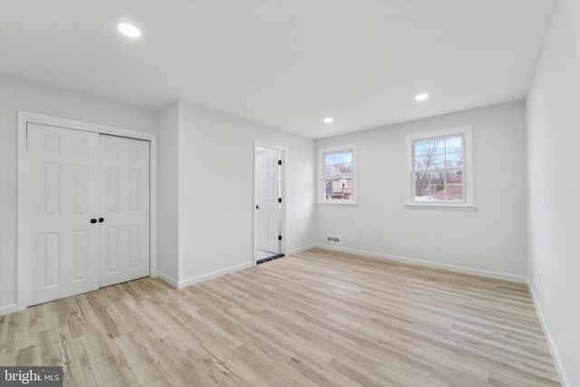 unfurnished bedroom featuring light hardwood / wood-style floors and a closet