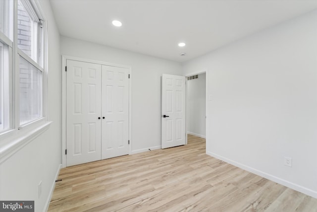 unfurnished bedroom featuring light hardwood / wood-style floors and a closet