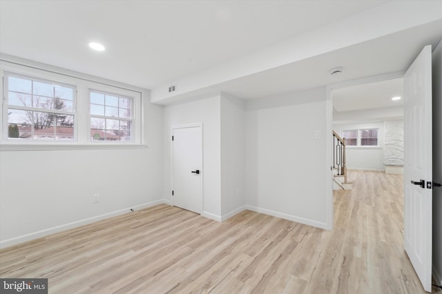 empty room with a wealth of natural light and light wood-type flooring