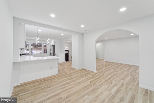 living room featuring sink and light hardwood / wood-style flooring