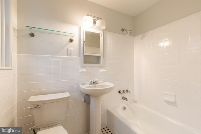 full bathroom featuring tile walls, sink, toilet, and shower / bath combination