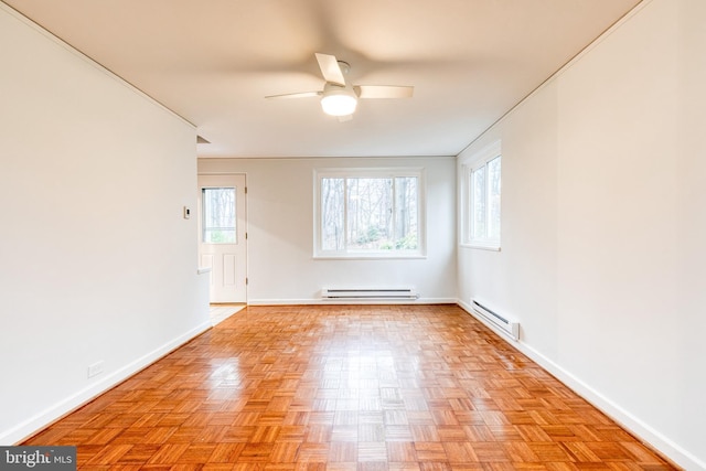 unfurnished room featuring light parquet flooring, a baseboard heating unit, and a wealth of natural light