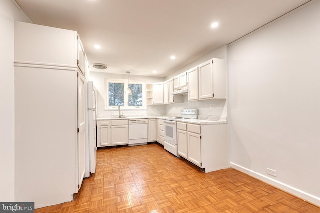 kitchen featuring white appliances, light parquet flooring, decorative light fixtures, and white cabinets