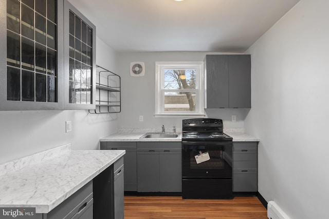 kitchen with gray cabinets, black electric range, sink, and light wood-type flooring