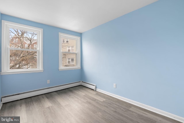 empty room with light hardwood / wood-style floors and baseboard heating