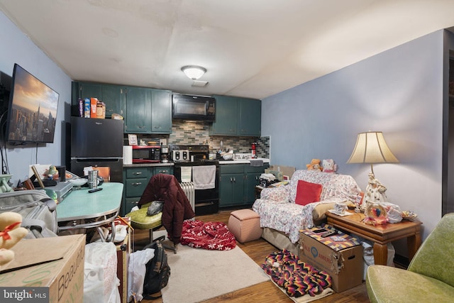 kitchen with hardwood / wood-style flooring, tasteful backsplash, and black appliances