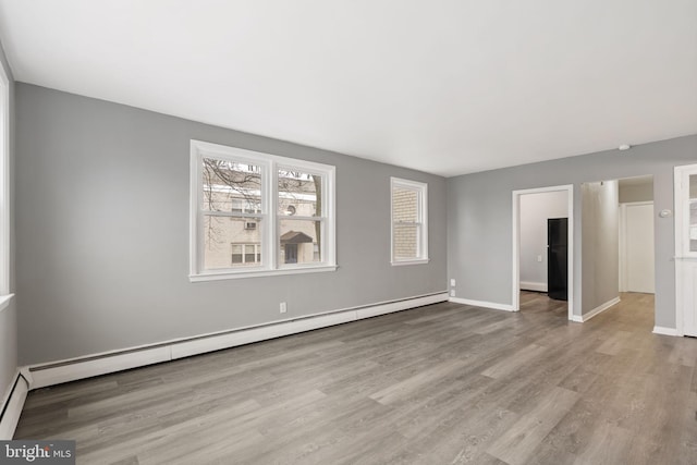 empty room featuring light hardwood / wood-style flooring and a baseboard heating unit