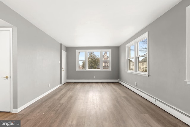 unfurnished room with a baseboard radiator and wood-type flooring