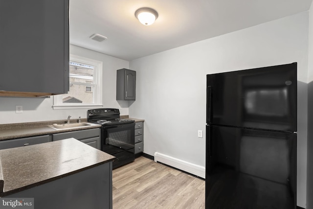 kitchen with sink, gray cabinetry, light hardwood / wood-style flooring, baseboard heating, and black appliances