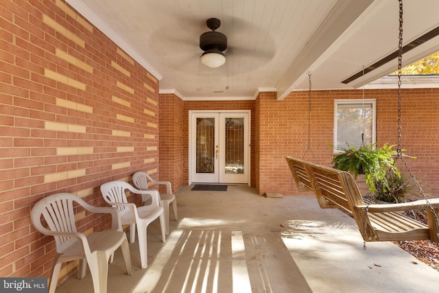 view of exterior entry with french doors, ceiling fan, and a patio area