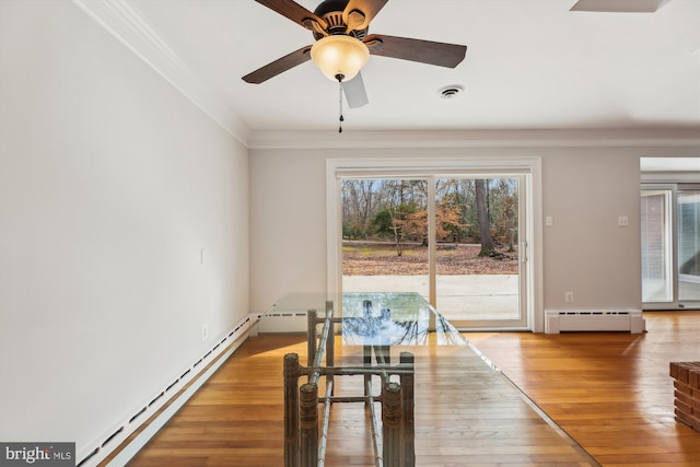 dining space with crown molding, a baseboard radiator, ceiling fan, and hardwood / wood-style floors