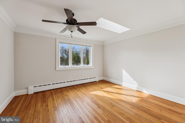 unfurnished room featuring a skylight, hardwood / wood-style flooring, a baseboard heating unit, ceiling fan, and crown molding