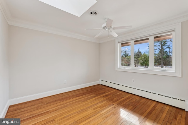 unfurnished room with crown molding, a baseboard radiator, a skylight, and light hardwood / wood-style floors