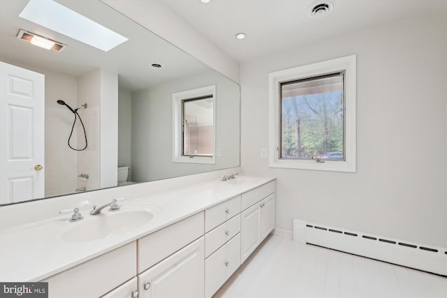 bathroom featuring a skylight, a shower, vanity, baseboard heating, and toilet